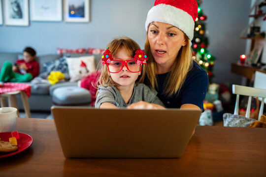 Mom and kid doing Christmas online shopping with laptop and credit card