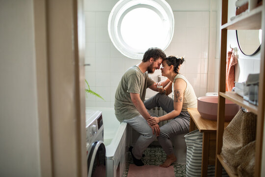 Couple celebrating positive pregnancy test together in bathroom