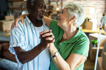 Happy senior couple dancing after moving into new home