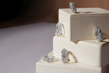 Jewelry with precious stones. Jewelry made of silver and stones on a paper box. Rings made of metal...