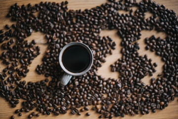 A cup of coffee surrounded by a rich arrangement of roasted coffee beans with 2025 numbers