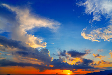 Bright blue-orange sky with picturesque clouds in the sky and the ocean in the distance islands