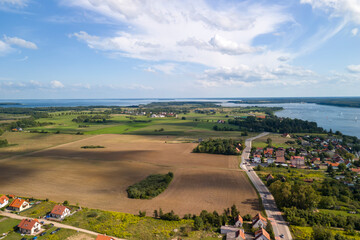 Scenic aerial view of lush green fields, a river, and a peaceful village. Perfect for nature and travel themes.