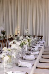 Elegant table setting with white flowers and napkins.