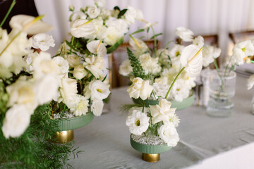 Compositions of white flowers on the festive table