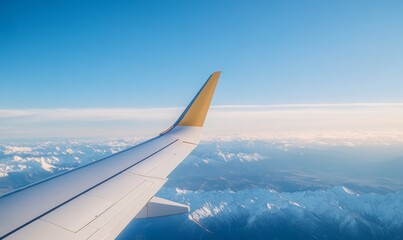 View From an Airplane Wing Overlooking Snow-Capped Mountains and Clear Skies During Daytime Travel