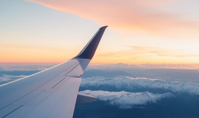 Obraz premium Aerial View From an Airplane Wing Over Snow-Capped Mountains at Sunset
