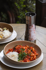 Ravioli with tomato sauce in a bowl on wooden table