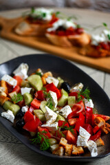 Greek salad with feta cheese, tomatoes, cucumbers, onions and croutons