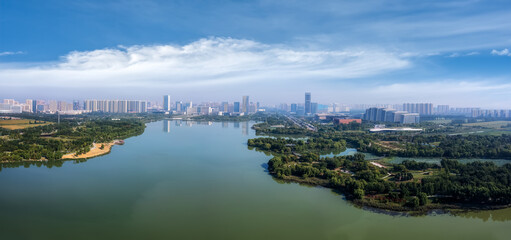Naklejka premium Scenic Urban River View: Nature Meets Modern City Skyline