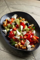 Greek salad with feta cheese, tomatoes, cucumbers, onions and croutons