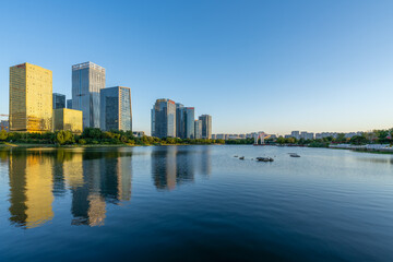 Fototapeta premium Serene Urban Cityscape Reflected on Calm Water at Dawn