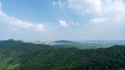 Expansive Aerial View of Lush Green Mountains Overlooking a Cityscape