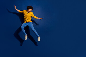 Obraz premium Full size photo of nice young man jump empty space isolated on dark blue color background