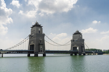 Obraz premium Stunning Suspension Bridge with Majestic Towers Over Serene Water