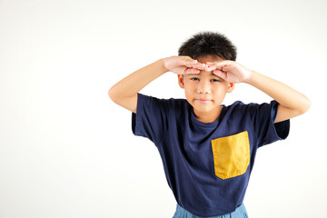 Searching concept. Asian young boy kid looking far away with hand over head at studio shot isolated on white background, Portrait of Happy primary child looking at distance with eyes shaded