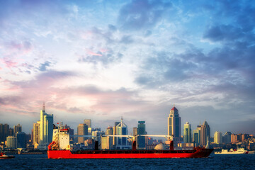 Vibrant Cityscape with a Cargo Ship Against an Evening Sky