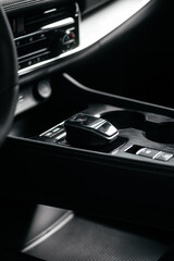 Modern car center console with electronic gear selector, stylish design, and control buttons. Ideal for automotive content, advertising, and blogs, highlighting comfort and technology