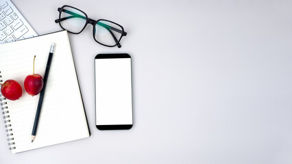 Top view of mock up modern workspace with blank screen smartphone, keyboard. Office situation with keyboard and accessories isolated on white. Copy space, Flat lay.