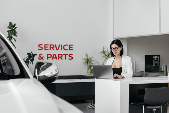 Sales woman use smartphone, have business call at car showroom. Car dealership client service and parts. Business Process and Problem Solving, Quality Control. Cell phone advise to choose, buy auto