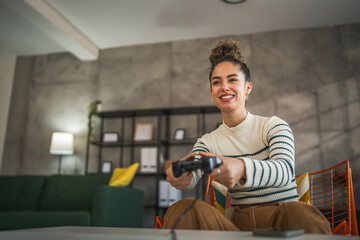 One young woman hold joystick play console video game at home