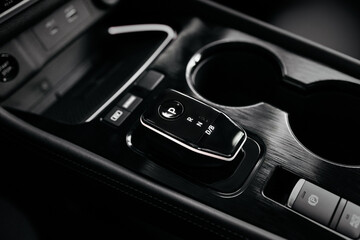Modern car center console with electronic gear selector, stylish design, and control buttons. Ideal...