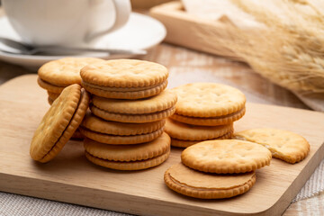 Sandwich crackers filled with peanut butter flavored cream on wooden plate