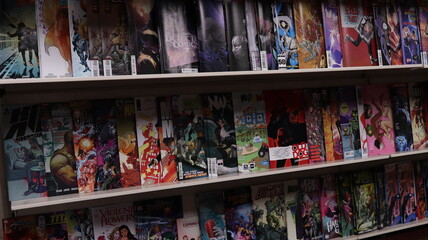Obraz premium CARDIFF, MID GLAMORGAN, WALES UK - OCTOBER 3, 2024: COMIC BOOKS ON SHELVES DISPLAY PAPERBACKS 