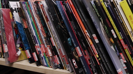 Obraz premium CARDIFF, MID GLAMORGAN, WALES UK - OCTOBER 3, 2024: COMIC BOOKS ON SHELVES DISPLAY PAPERBACKS 