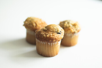 three blueberry muffins on white background