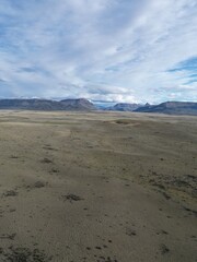 Aerial views of Patagonia, Argentina, featuring barren wastelands, rugged mountains, and dry plains. The photos capture the vast, remote wilderness, highlighting the dramatic Andean peaks.