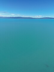 Aerial views of Argentino Lake in Patagonia, Argentina, showing its striking turquoise waters and rugged shoreline. The images capture the expansive wilderness, surrounded by mountains and serene land