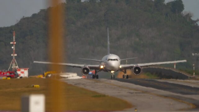 Footage of passenger jet and fire trucks on taxiway. Airliner taxiing to terminal after landing gear caught fire. Flight abort emergency