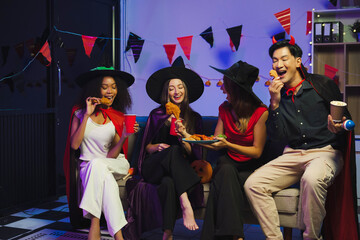 Obraz premium Dinner and group of people celebrating together at Halloween party.