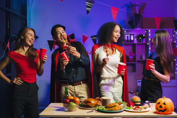 Dinner and group of people celebrating together at Halloween party.