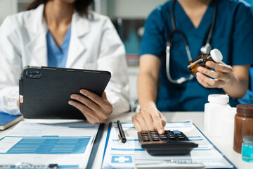 Doctor or accounting department writes a note and uses a calculator to calculate expenses - income. of hospital staff.