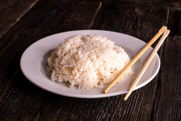 White rice in bowl on wood table on a black background. Chinese food. Food concept.