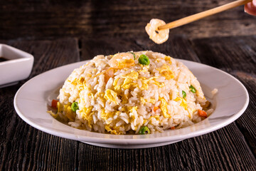 White rice in bowl on wood table. Chinese food. wooden sticks, soy sauce