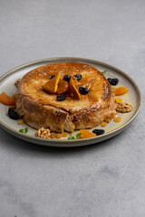 cake with dried apricots, raisins and walnuts on grey background