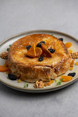 cake with dried apricots, raisins and walnuts on grey background