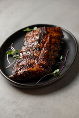 Grilled ribs with radish and microgreen on a plate