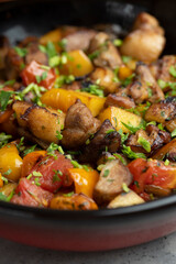 Fried meat with vegetables in a ceramic bowl on a light background. Selective focus.