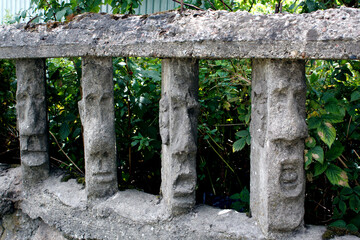 Naklejka premium stone fence with human faces