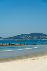 View of Playa de Samil, the main beach of Vigo in Galicia in northwest Spain. Sunny day, crystal clear blue sea