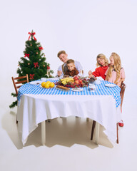 Family sits at beautifully decorated holiday table, enjoying Christmas desserts. Their smiles reflect joy of festive season. Concept of Christmas, family, joy, holiday meal, celebration.