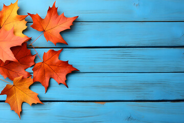 Obraz premium Vibrant Autumn Maple Leaves on Wooden Blue Background Creating a Seasonal Atmosphere