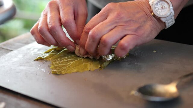 People cook dolma food.
Grape leaves stuffed with minced meat.
