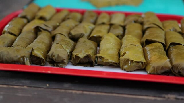 People cook dolma food.
Grape leaves stuffed with minced meat.