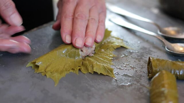 People cook dolma food.
Grape leaves stuffed with minced meat.
