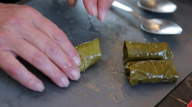 People cook dolma food.
Grape leaves stuffed with minced meat.